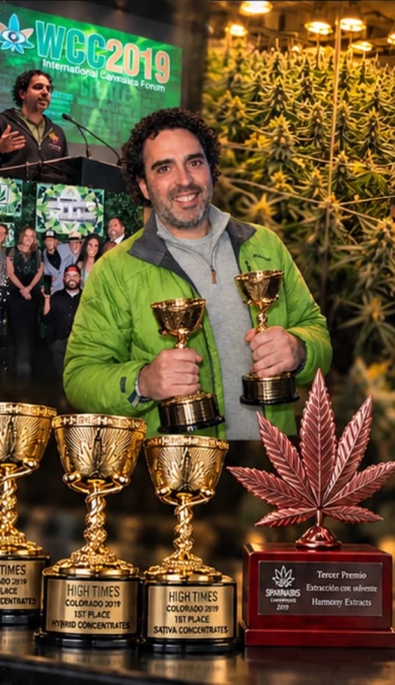 Lee Weiner holding two award trophies, with a row of High Times Colorado 2019 first-place trophies in front of him
